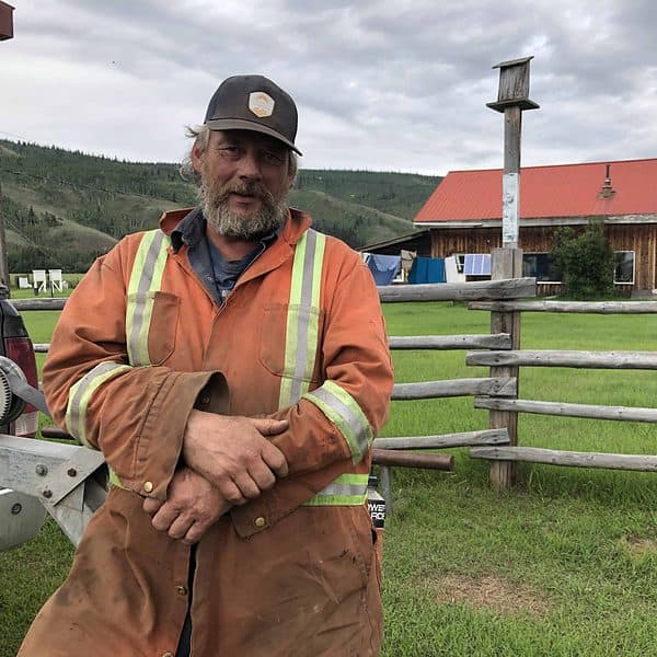 Dale Bradley posing for a photo outside his farm house